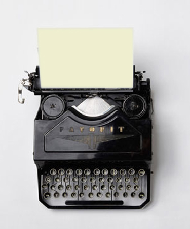 Schreiben. Foto einer alte schwarzen Schreibmaschine mit gelbem Blatt Papier